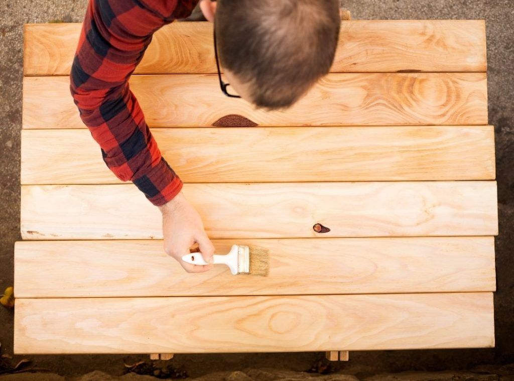 Tradie painting wood | Featured image for Types of Wood Defects to Look for When Building | Blog.