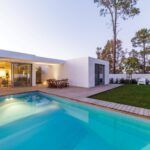 Luxury home with pool and deck next to a white coloured home | Featured Image for the Decking Timber Brisbane Page of Versace Timbers.